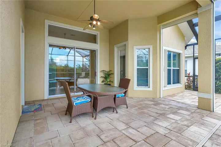 Covered Lanai with electric roll down shades.  Sliding doors lead to family room and kitchen.  Door on Right leads to Primary Bedroom and door on left leads to guest rooms and pool bath.