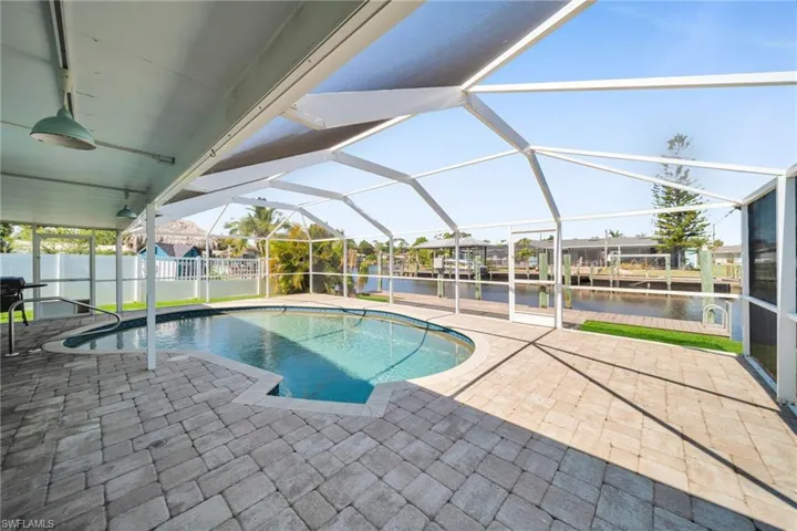 View of swimming pool featuring a water view, a lanai, and a patio area
