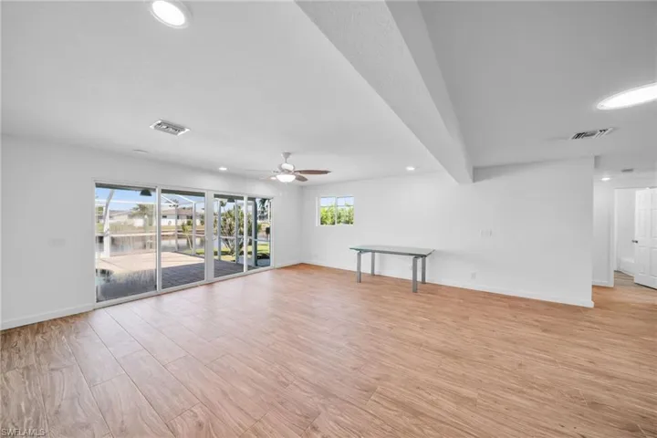 Spare room with baseboards, ceiling fan, visible vents, and light wood-style floors