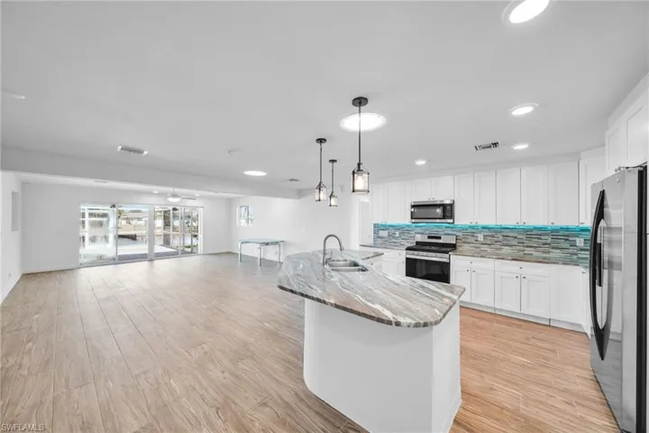 Kitchen featuring visible vents, tasteful backsplash, appliances with stainless steel finishes, a sink, and open floor plan