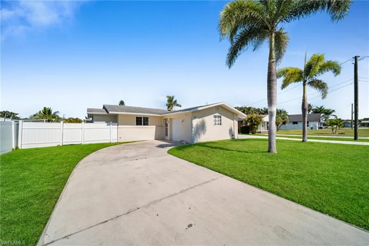View of front of house with stucco siding, an attached garage, fence, and driveway