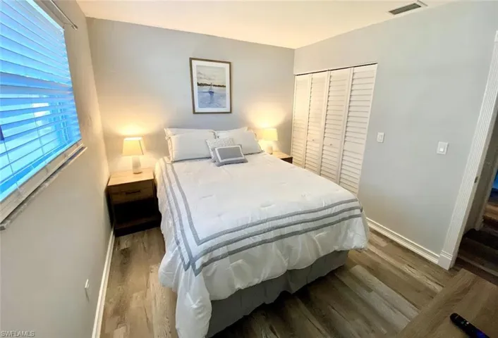 Bedroom featuring dark wood-type flooring and a closet