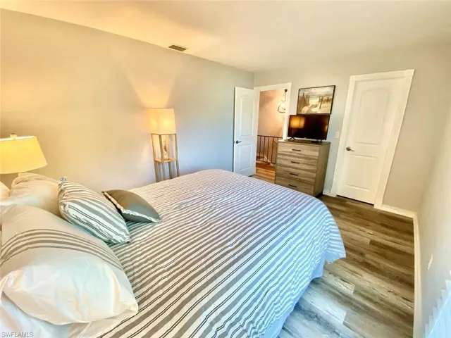Bedroom with wood finished floors and baseboards