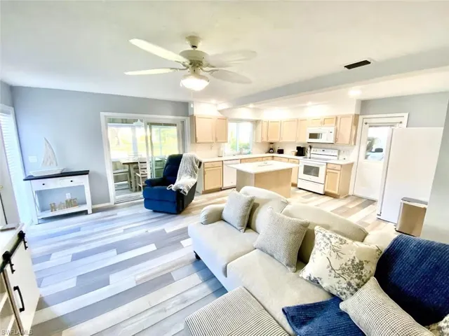 Living area with ceiling fan and baseboards