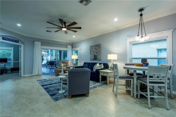 Living room with crown molding, ceiling fan, and recessed lighting