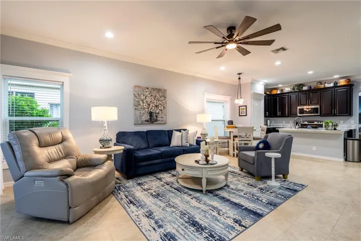 Living area featuring crown molding, ceiling fan, and recessed lighting