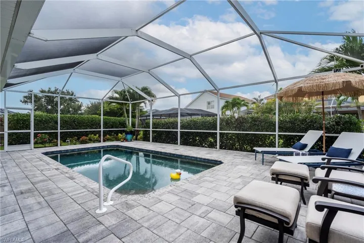 View of pool with a sunroom, glass enclosure, and a patio