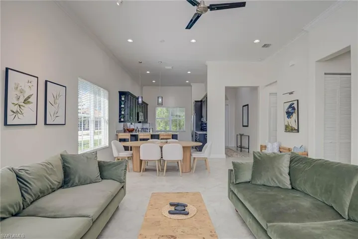 Living room with crown molding, recessed lighting, a ceiling fan, and light tile patterned floors