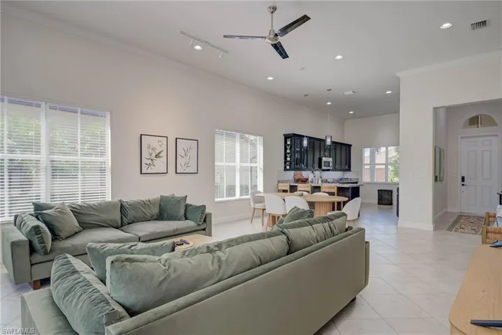 Living room featuring ornamental molding, light tile patterned floors, recessed lighting, and a ceiling fan