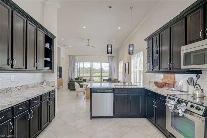 Kitchen featuring tasteful backsplash, ornamental molding, open shelves, a peninsula, and stainless steel appliances