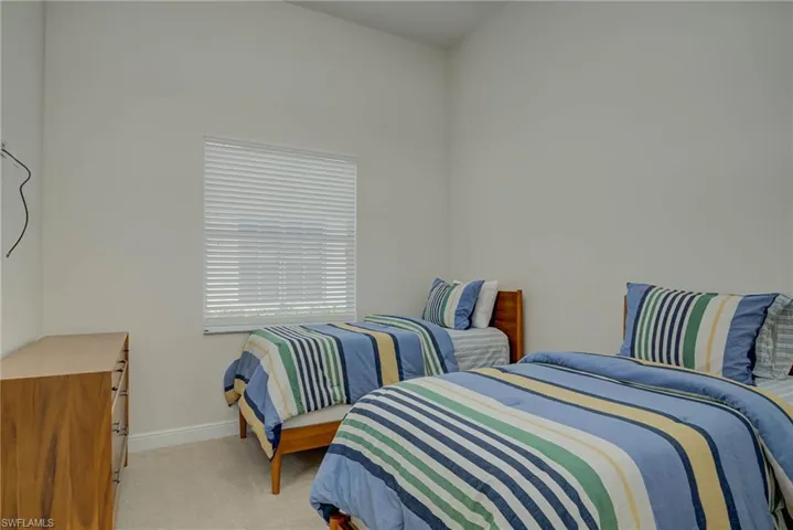 Bedroom featuring baseboards and light colored carpet