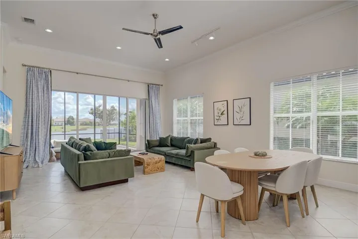 Dining room featuring ornamental molding, plenty of natural light, ceiling fan, light tile patterned floors, and recessed lighting