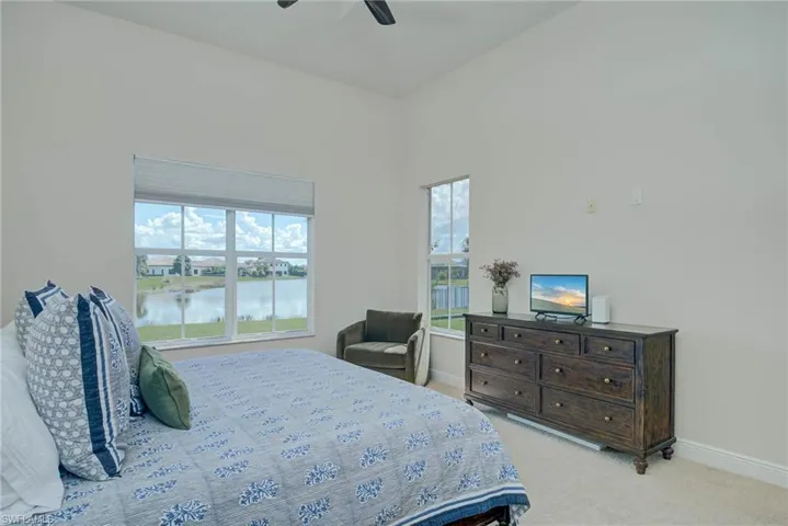Bedroom with light colored carpet and ceiling fan