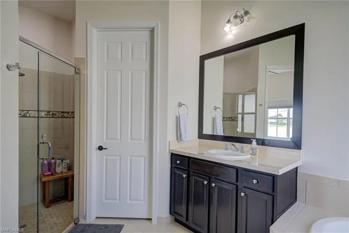 Full bathroom featuring vanity, a shower stall, and light tile patterned flooring