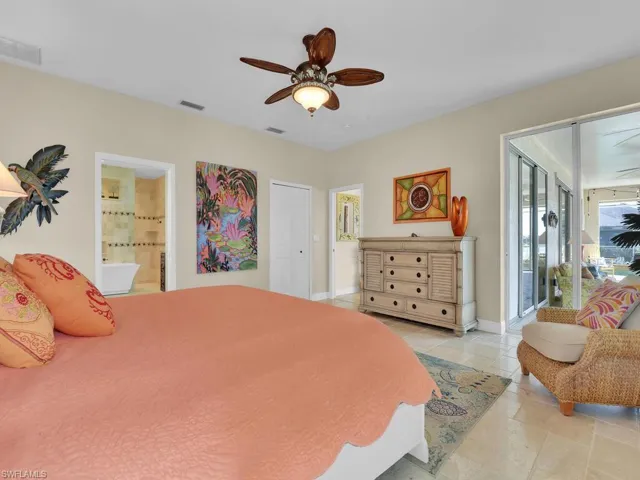 Bedroom with a closet, ensuite bathroom, access to exterior, and ceiling fan