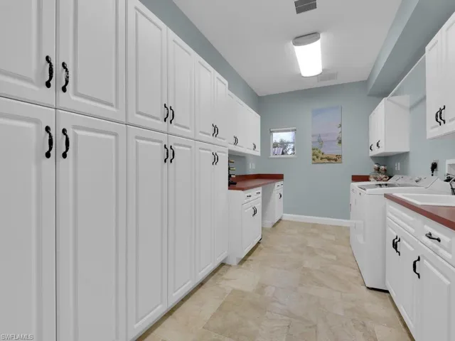 Kitchen featuring white cabinets and washer and dryer