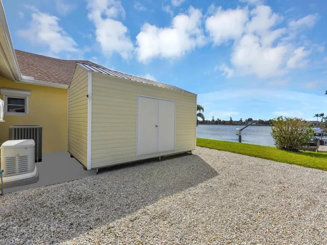 View of outbuilding with a water view and central air condition unit