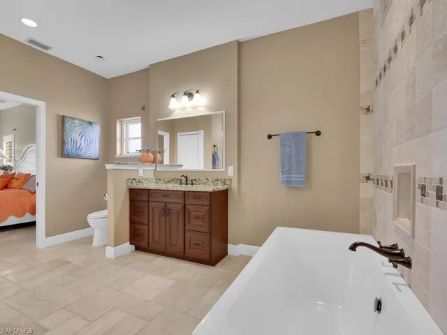 Bathroom featuring toilet, vanity, and a bath
