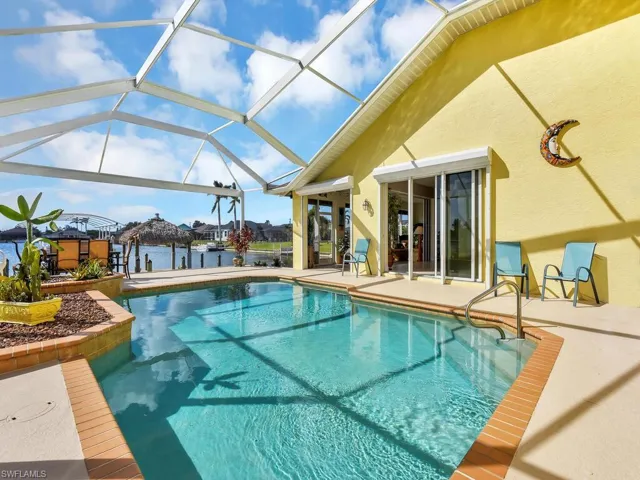 View of swimming pool with a water view, a patio area, and a lanai