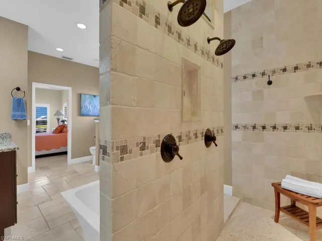 Bathroom featuring vanity, tile walls, and tiled shower