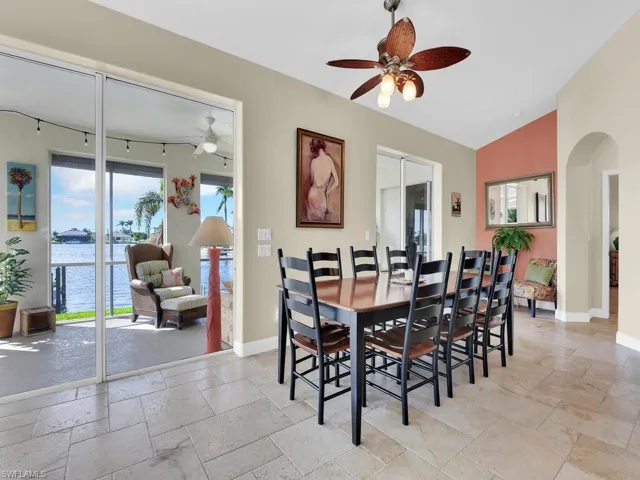 Dining area with ceiling fan, a water view, and vaulted ceiling
