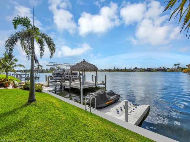 View of dock featuring a yard and a water view