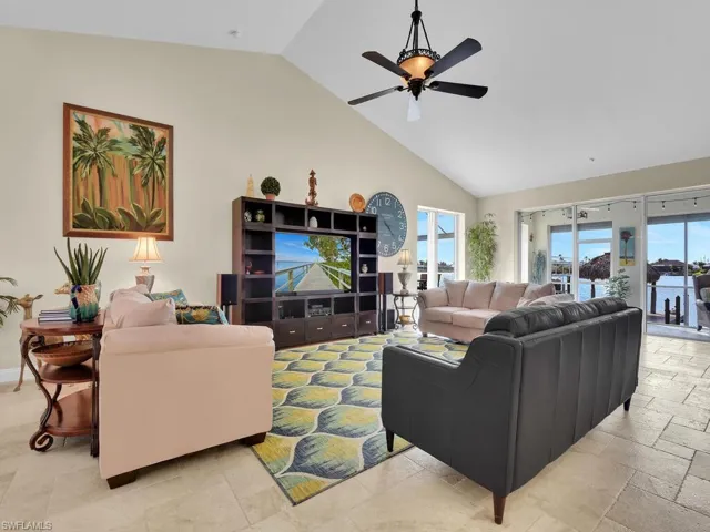 Living room featuring a healthy amount of sunlight, high vaulted ceiling, and ceiling fan