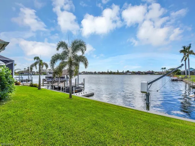 Dock area with a water view and a lawn