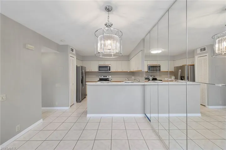 Open floorplan with designer mirrored storage and beautiful chandelier.