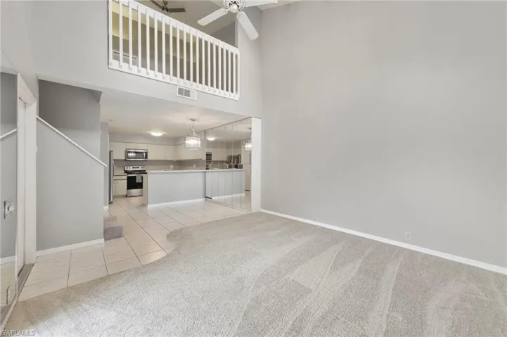 Dining area with designer mirrored storage and kitchen.