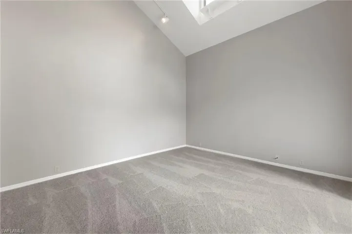 Living room with cathedral ceiling and sky light. Brand new carpet.