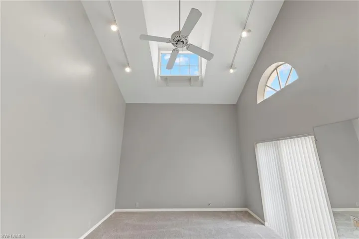 High ceiling in living room with track lighting.
