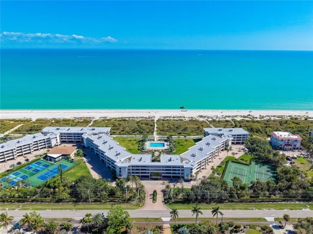 Drone / aerial view of waterfront with a beach and apartment complex / building