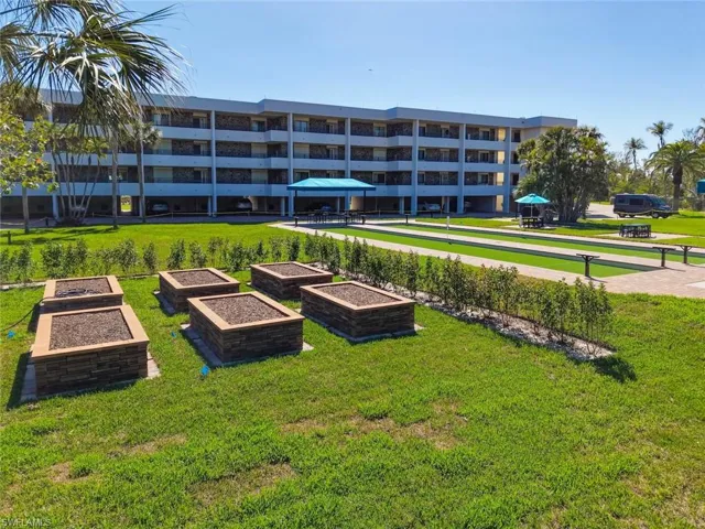 View of home's community featuring a bocce ball area and a garden
