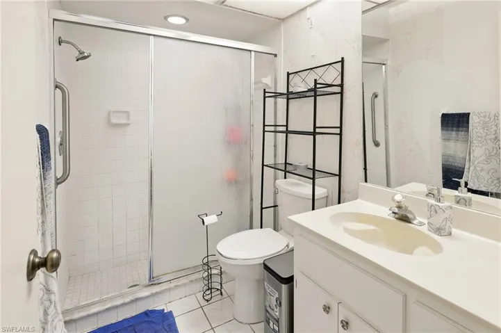 Bathroom with a shower stall, tile patterned floors, vanity, and toilet