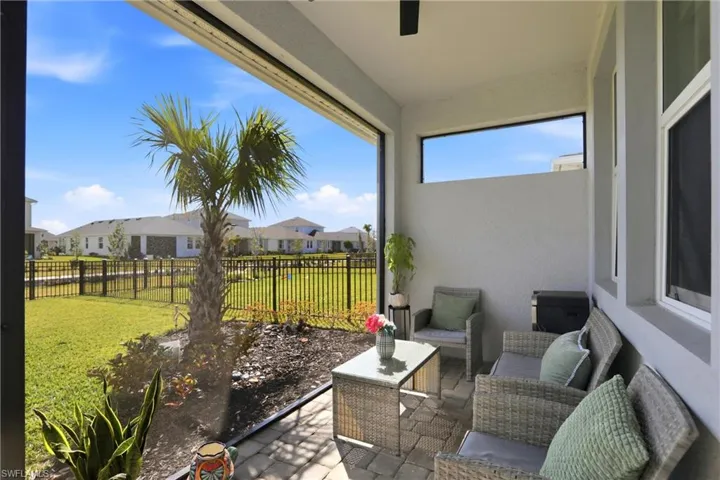Sunroom / solarium with a ceiling fan, a residential view, outdoor furniture, and a patio area