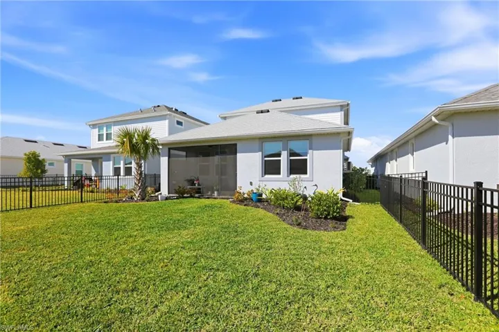 Back of house featuring a fenced backyard, stucco siding, and a sunroom