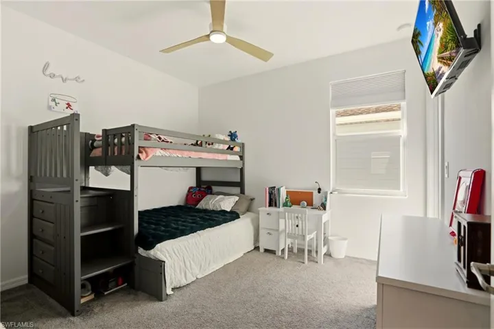 Bedroom with light carpet and a ceiling fan