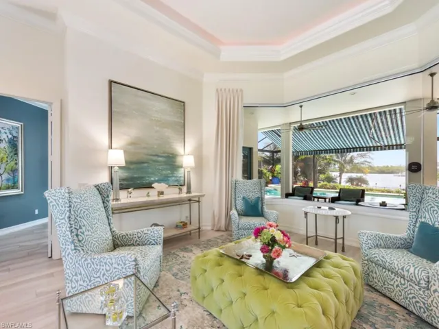 Living area featuring light hardwood / wood-style flooring, crown molding, and a raised ceiling