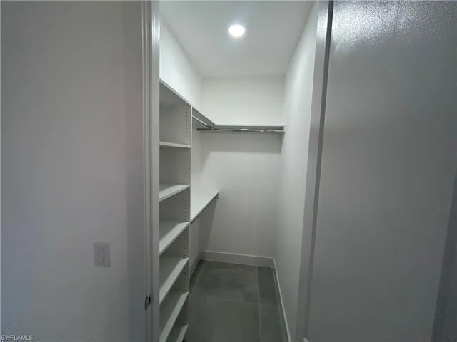 Walk in closet featuring dark tile patterned floors