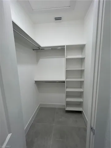Walk in closet featuring dark tile patterned floors
