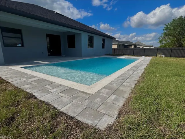 View of pool featuring a lawn and a patio