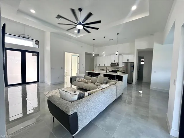 Living room with a tray ceiling and ceiling fan