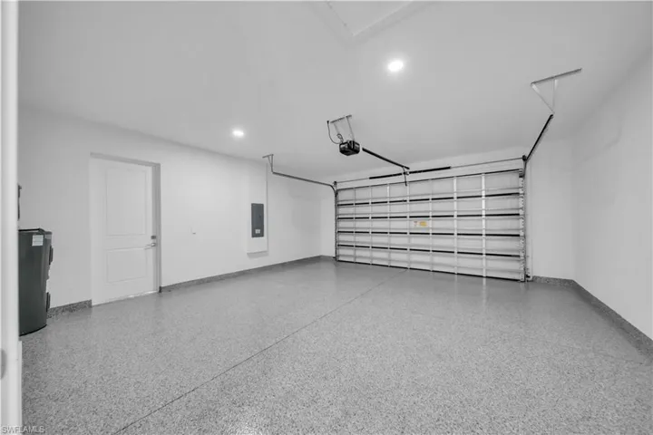 Garage with electric water heater, recessed lighting, and electric panel