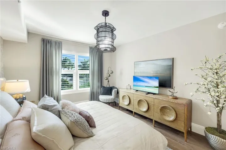 Bedroom featuring wood finished floors and a chandelier