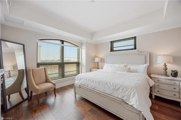 Bedroom featuring a raised ceiling and dark hardwood / wood-style floors