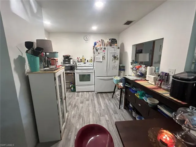 Kitchen featuring white appliances, light wood-style floors, and recessed lighting