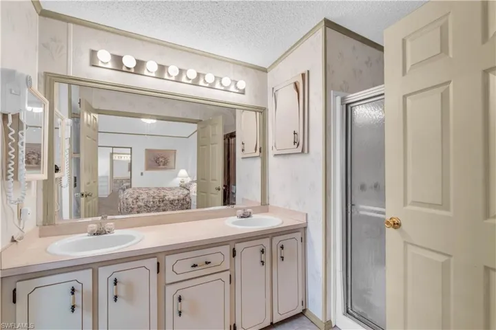 Bathroom featuring dual vanity and a textured ceiling