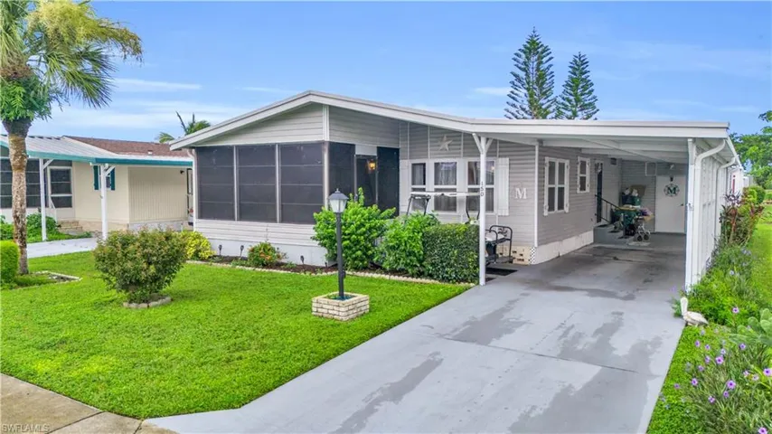 Manufactured / mobile home with a front lawn and a carport