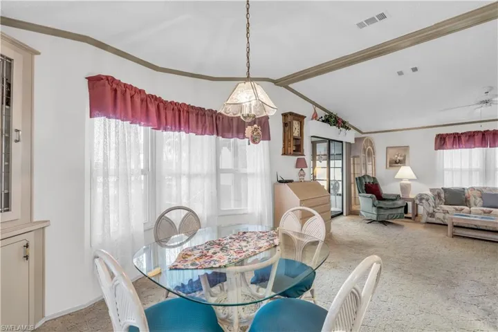 Dining room featuring carpet floors, lofted ceiling, and ceiling fan